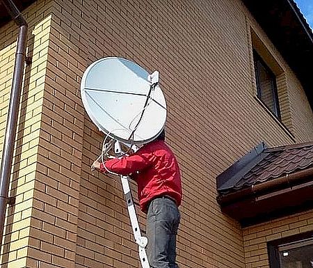 Мастер осуществляет работы по установке и настройке спутниковой антенны в Петропавловске-Камчатскому